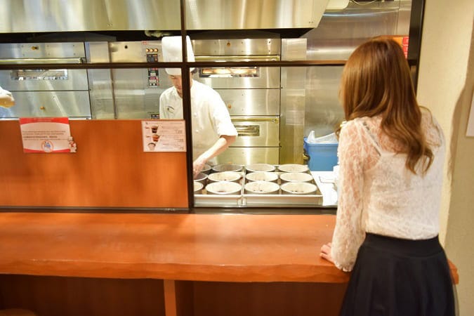 なんば本店でチーズケーキの工房をのぞく様子