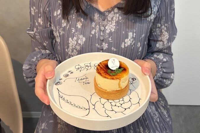「mignon luxe」のタルトを手に持つ様子